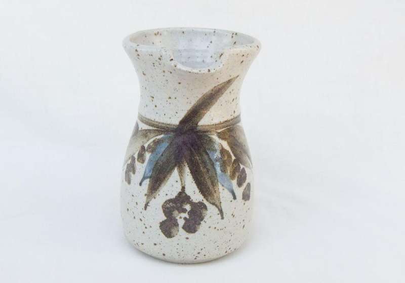 A vintage handmade and decorated Pottery beaker with makers stamp