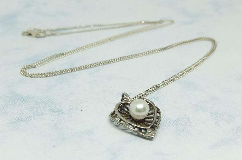 A BRAND NEW STERLING SILVER NECKLACE PLUS A HEART SHAPED VINTAGE PENDANT SET WITH A GENUINE PEARL