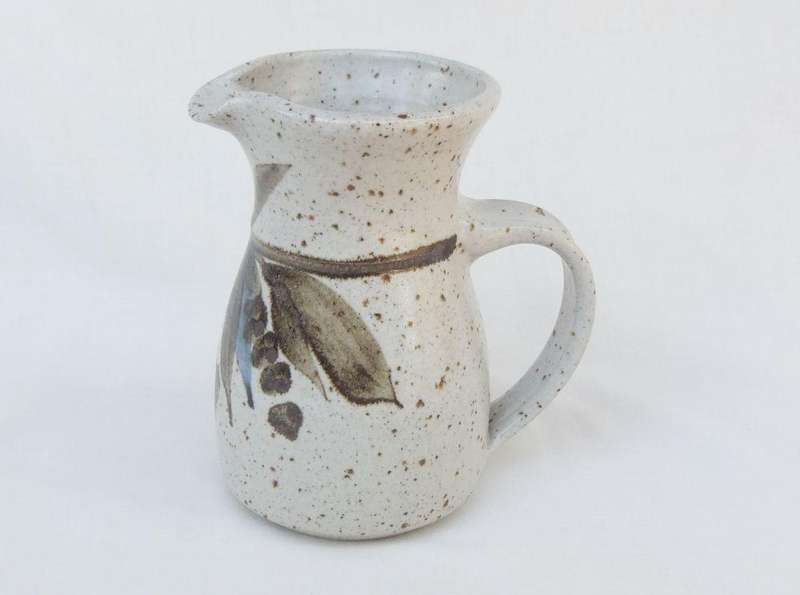 A vintage handmade and decorated Pottery beaker with makers stamp