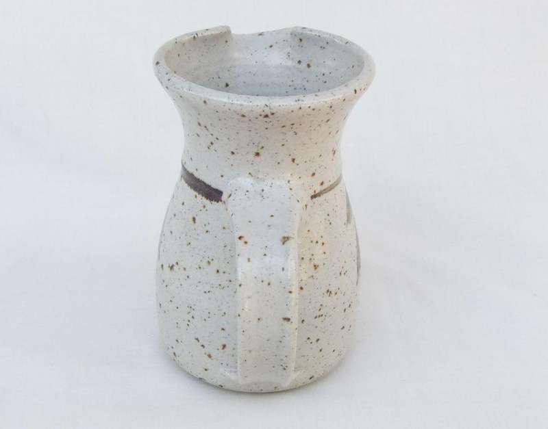A vintage handmade and decorated Pottery beaker with makers stamp