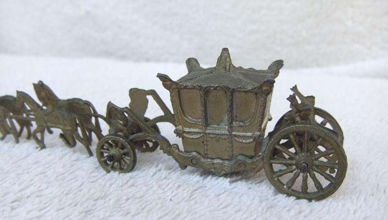 AN OLD METAL HORSE AND COACH ORNAMENT