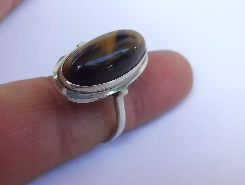 AN ART DECO STYLE VINTAGE STERLING SILVER RING SET WITH A CABOCHON GENUINE TIGERS EYE STONE