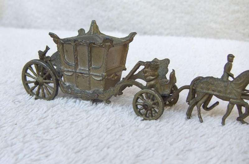 AN OLD METAL HORSE AND COACH ORNAMENT