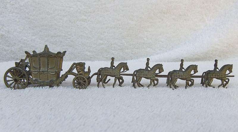 AN OLD METAL HORSE AND COACH ORNAMENT
