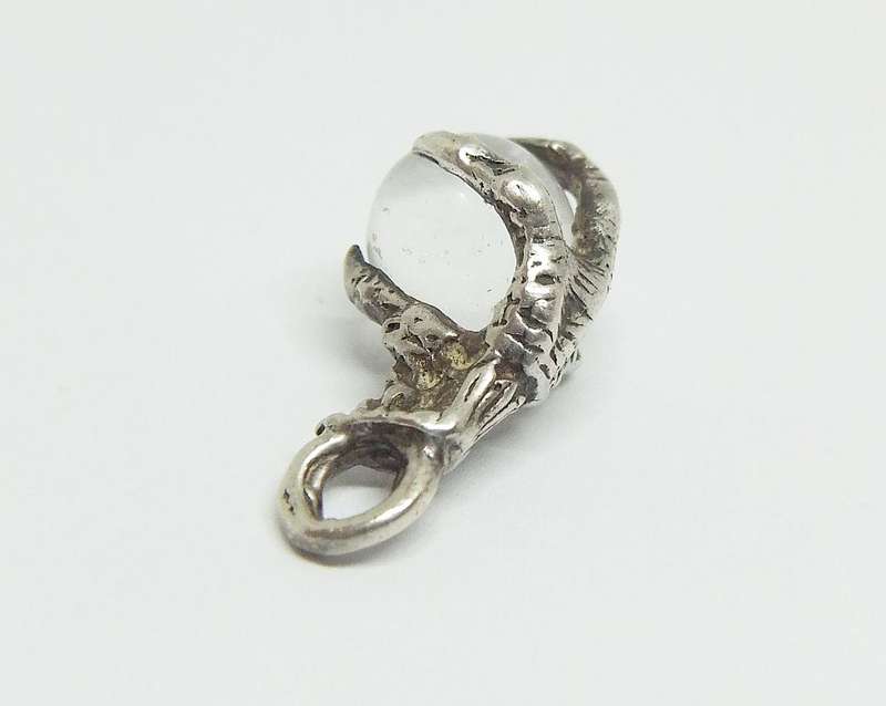AN OLD LOOKING STERLING SILVER PENDANT OR CHARM MODELED AS AN EAGLES CLAW HOLDING A GLASS ORB !!