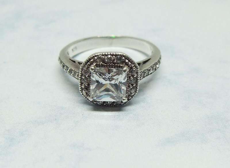 AN ENGAGEMENT STYLE SOLID STERLING SILVER RING SET WITH FACETED CZ STONES