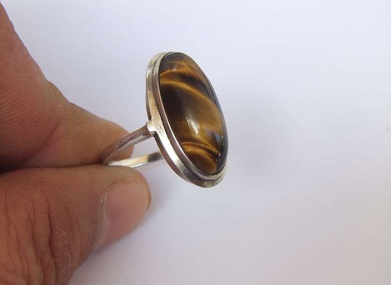 AN ART DECO STYLE VINTAGE STERLING SILVER RING SET WITH A CABOCHON GENUINE TIGERS EYE STONE