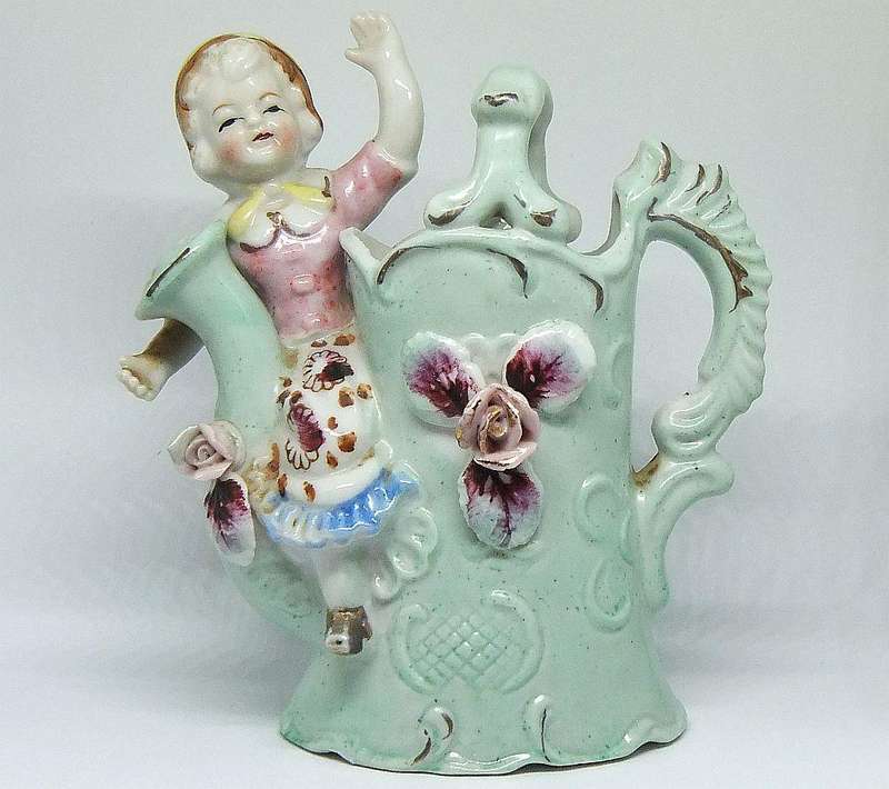 A RATHER KITSCH VINTAGE GIRL SITTING ON A WATERING CAN FIGURINE FLOWER POT IN GOOD CONDITION !!