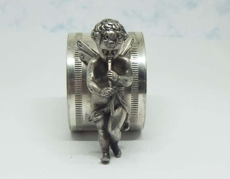 AN AMAZING RARE EARLY 1900`S FIGURAL SERVIETTE RING BY WMF GERMANY - CHERUB WITH FLUTE