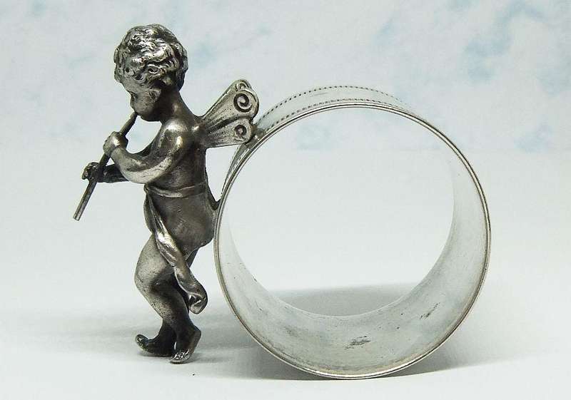 AN AMAZING RARE EARLY 1900`S FIGURAL SERVIETTE RING BY WMF GERMANY - CHERUB WITH FLUTE
