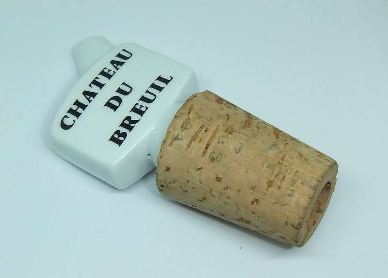 A VINTAGE PORCELAIN AND CORK ALCOHOL POURER