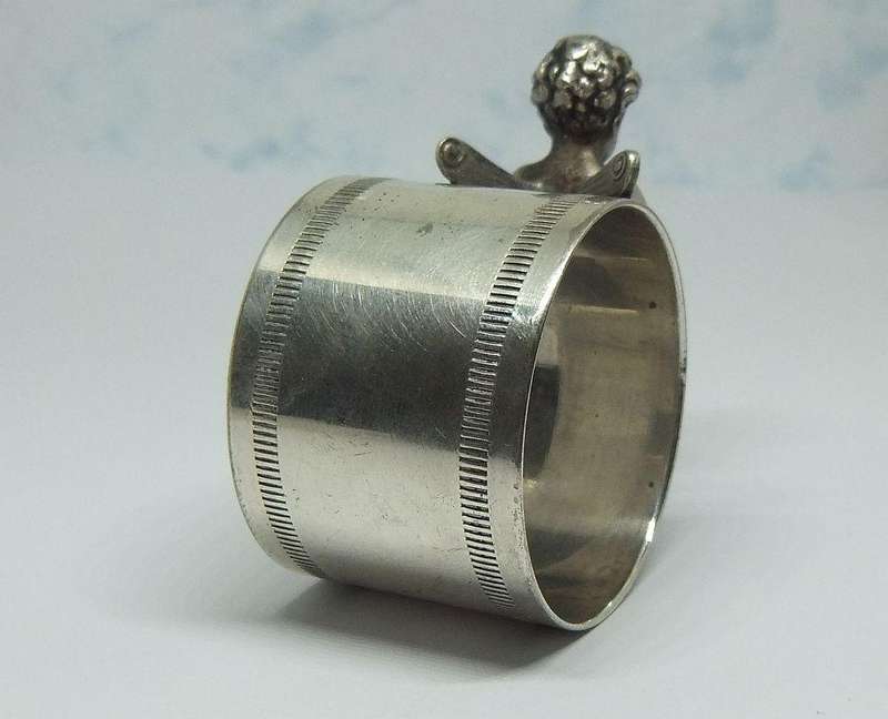 AN AMAZING RARE EARLY 1900`S FIGURAL SERVIETTE RING BY WMF GERMANY - CHERUB WITH FLUTE