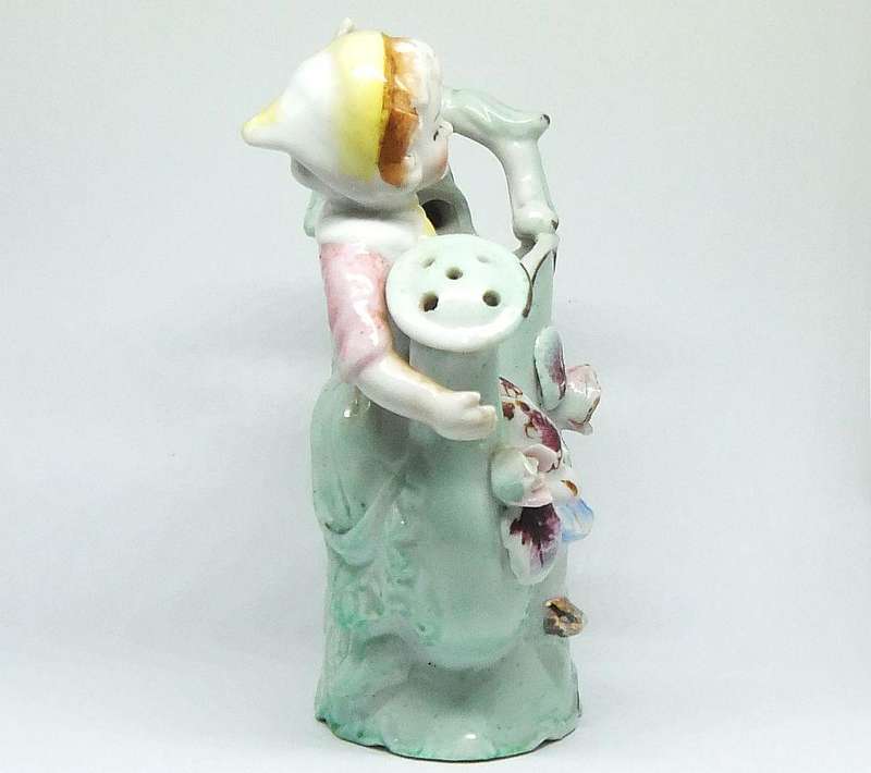 A RATHER KITSCH VINTAGE GIRL SITTING ON A WATERING CAN FIGURINE FLOWER POT IN GOOD CONDITION !!