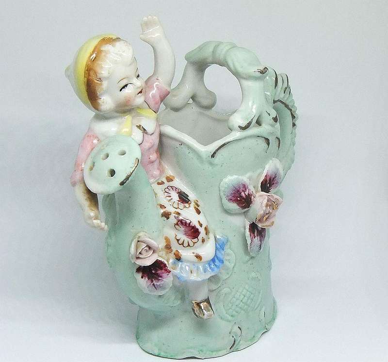 A RATHER KITSCH VINTAGE GIRL SITTING ON A WATERING CAN FIGURINE FLOWER POT IN GOOD CONDITION !!