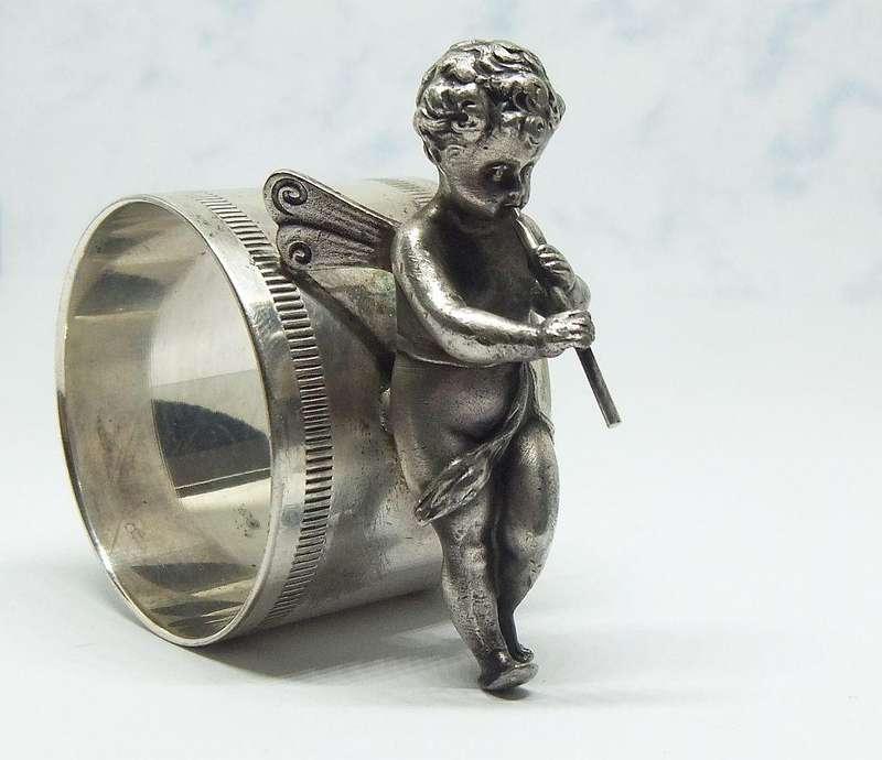 AN AMAZING RARE EARLY 1900`S FIGURAL SERVIETTE RING BY WMF GERMANY - CHERUB WITH FLUTE