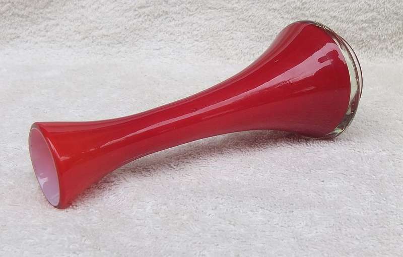 A STYLISH VINTAGE HAND BLOWN RED GLASS VASE WITH WHITE COLOURED INNER LINING