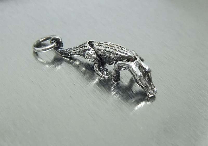 A VINTAGE ARTICULATED SOLID STERLING SILVER CROCODILE CHARM - HEAD POPS UP WHEN YOU PRESS HIS BACK