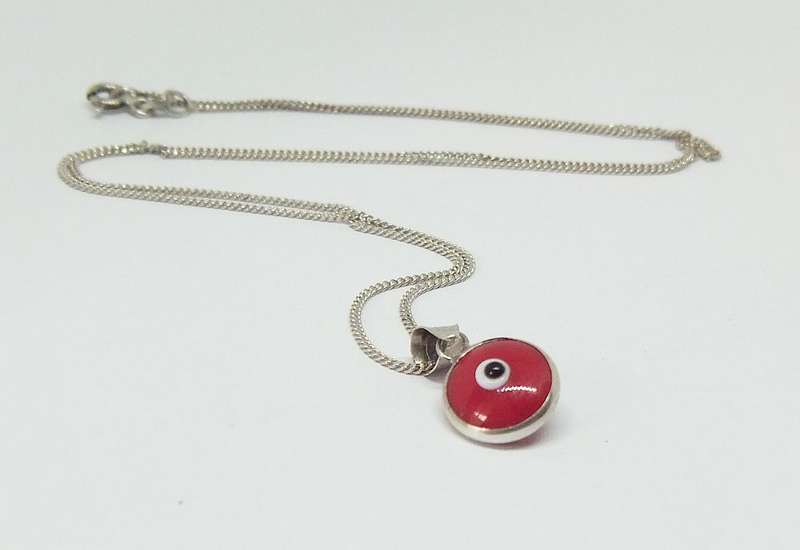 AN UNUSUAL STERLING SILVER AND RED GLASS EYE PENDANT WITH A STERLING SILVER NECKLACE !!