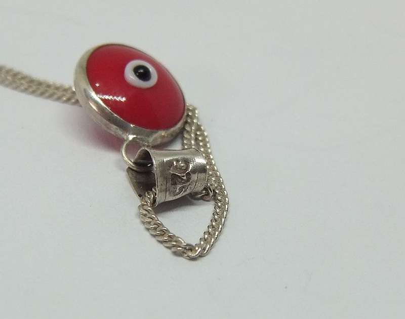 AN UNUSUAL STERLING SILVER AND RED GLASS EYE PENDANT WITH A STERLING SILVER NECKLACE !!