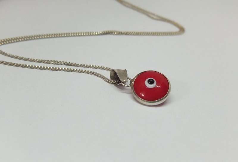 AN UNUSUAL STERLING SILVER AND RED GLASS EYE PENDANT WITH A STERLING SILVER NECKLACE !!