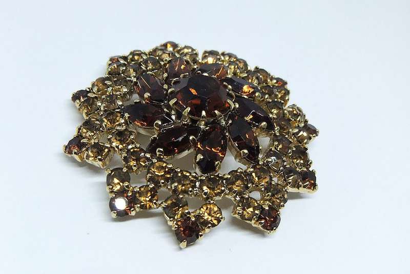 A SPARKLY VINTAGE BROOCH WITH LOTS OF FACETED AMBER COLOURED INSETS