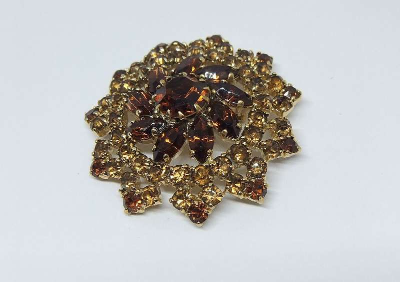 A SPARKLY VINTAGE BROOCH WITH LOTS OF FACETED AMBER COLOURED INSETS
