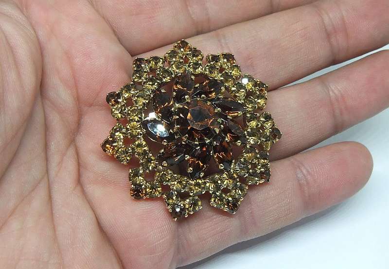 A SPARKLY VINTAGE BROOCH WITH LOTS OF FACETED AMBER COLOURED INSETS