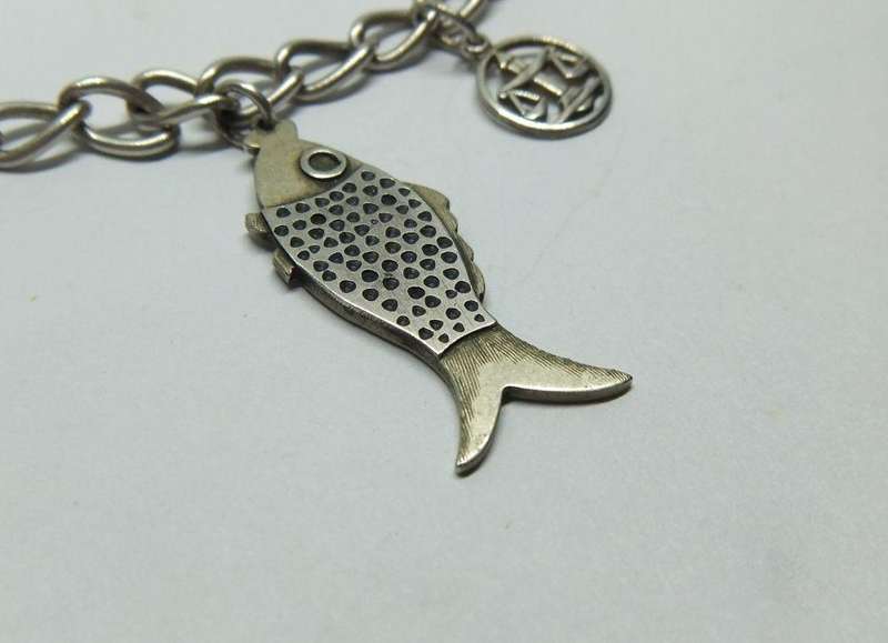 A VERY COOL VINTAGE STERLING SILVER CHARM BRACELET WITH VARIOUS DEGREES OF SILVER CHARMS , JUST LOOK