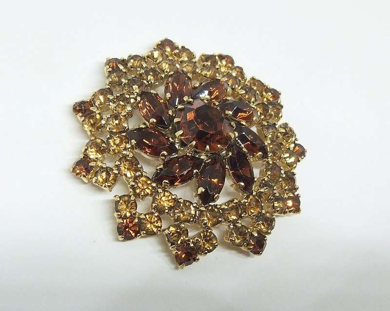 A SPARKLY VINTAGE BROOCH WITH LOTS OF FACETED AMBER COLOURED INSETS