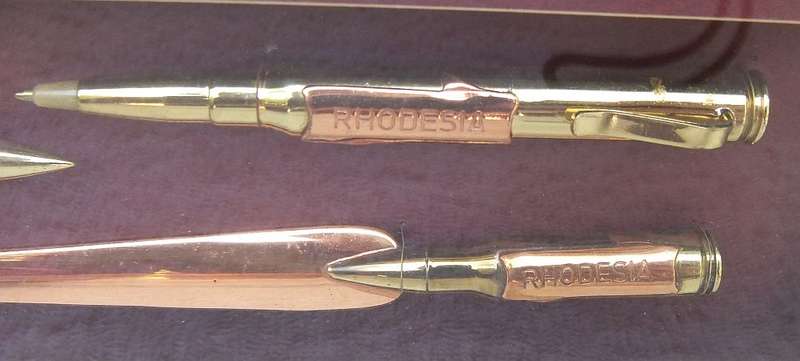 RARE FIND !! A VINTAGE BOX FRAME CONTAINING THREE PIECES OF RHODESIAN BUSH WAR TRENCH ART !! WOW !!
