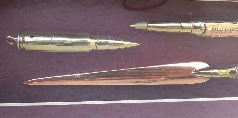 RARE FIND !! A VINTAGE BOX FRAME CONTAINING THREE PIECES OF RHODESIAN BUSH WAR TRENCH ART !! WOW !!