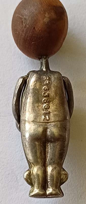 A WWI Fumsup lucky charm | Silver | has articulated arms |