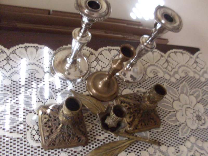 A COLLECTION OF CANDLE HOLDERS....SILVER PLATED AND BRASS