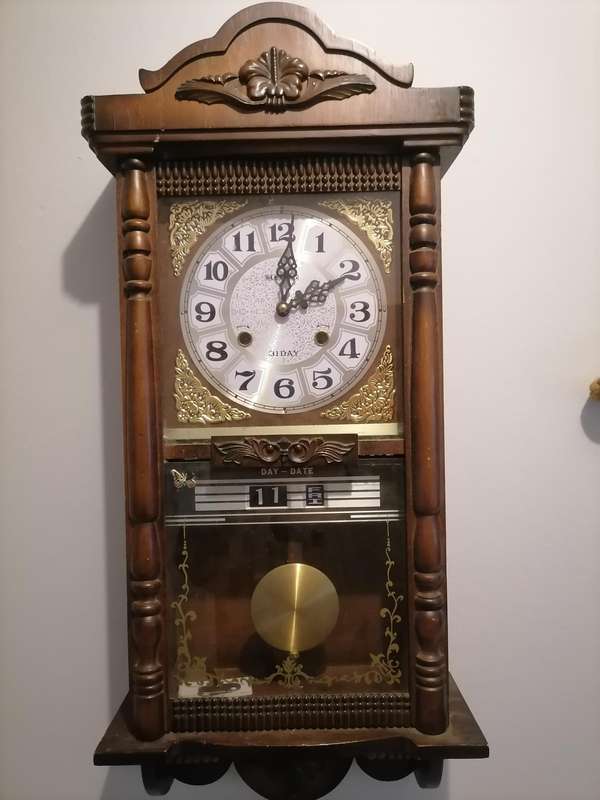 A vintage Blessing 31 day clock w/ day & date in a wood wall casing. Lifespace Sale - With Key