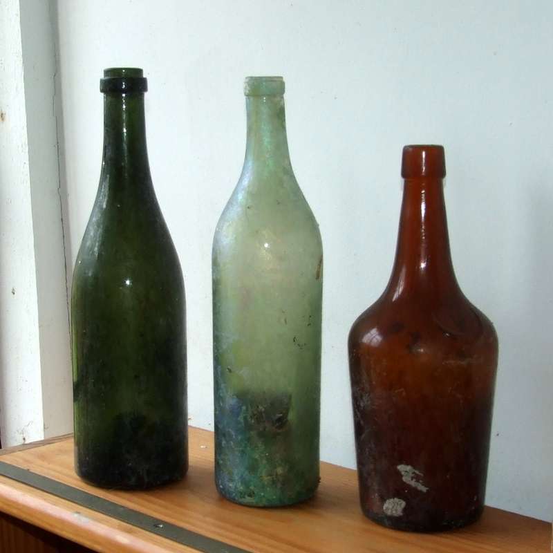 Three antique wine and brandy bottles