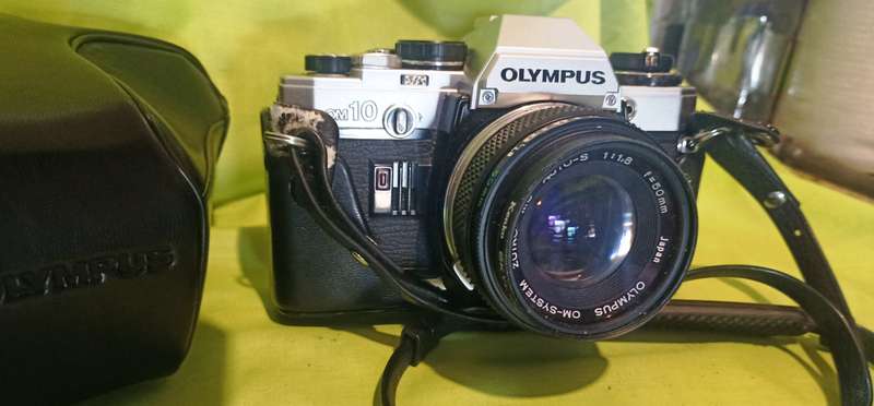 Olympus OM-10 camera with 50mm F 1.8 lens/light filters/lens cap/body cap/leather cover/manual