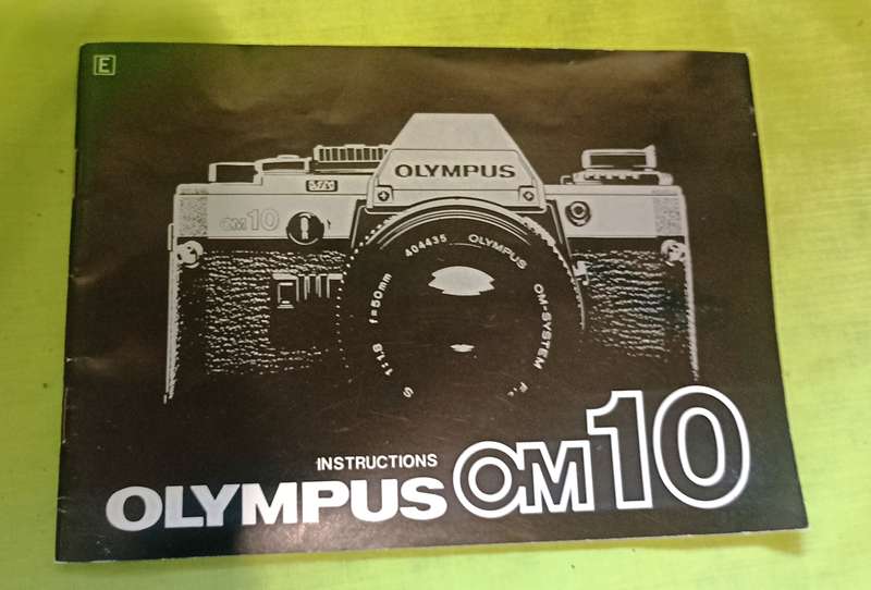 Olympus OM-10 camera with 50mm F 1.8 lens/light filters/lens cap/body cap/leather cover/manual