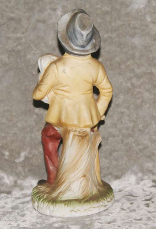 Vintage ceramic figurine of man holding dog