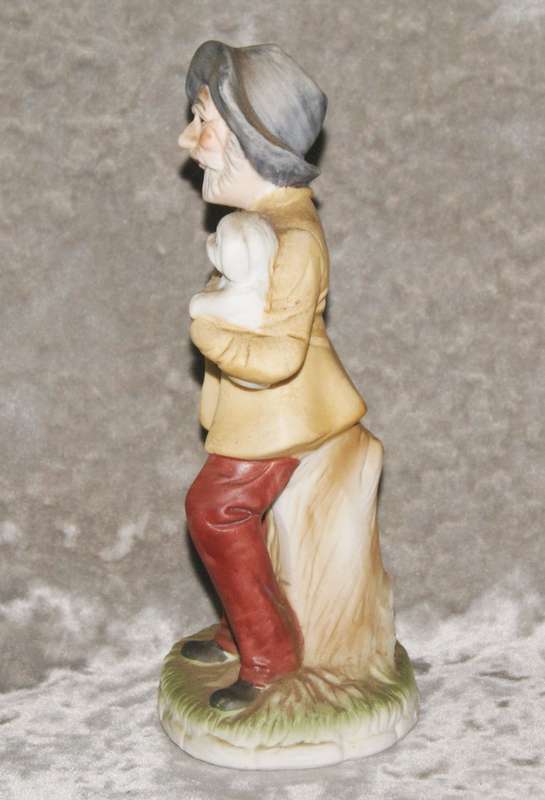 Vintage ceramic figurine of man holding dog