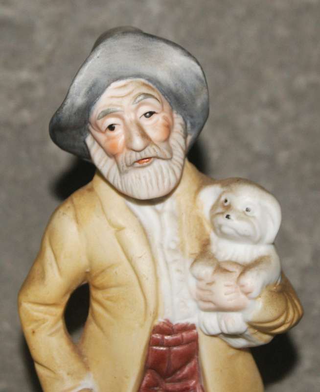 Vintage ceramic figurine of man holding dog