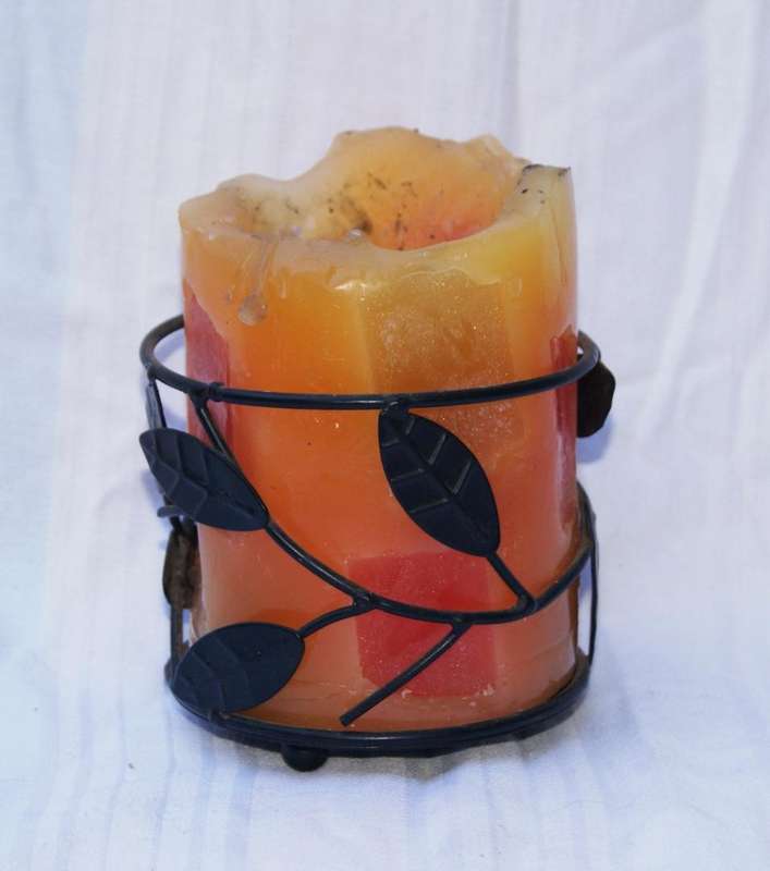 Partially used candle inside leaf design metal candle holder