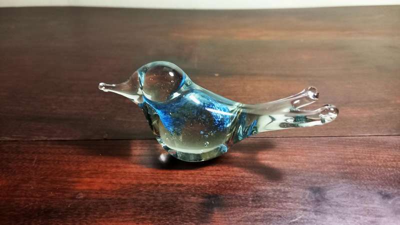 A SMALL DECORATIVE GLASS FIGURINE SHAPED LIKE A BIRD