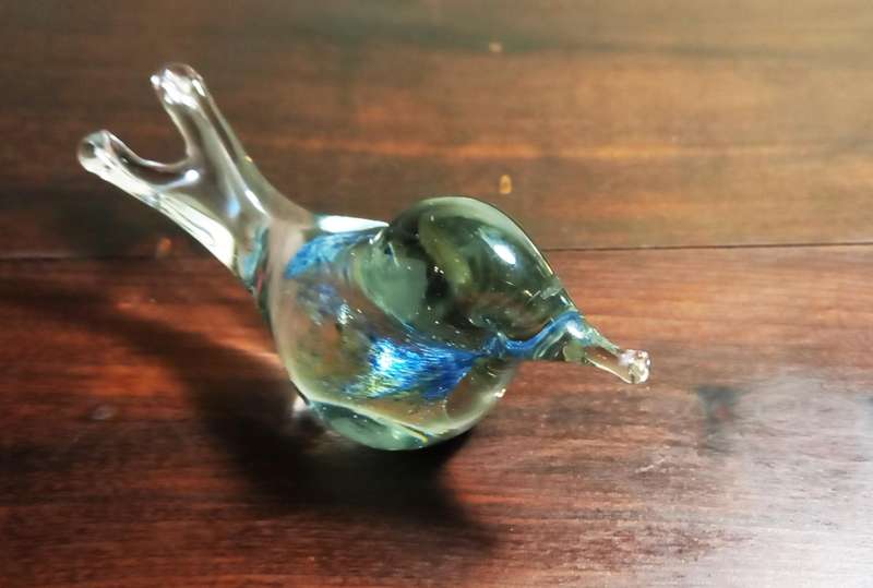 A SMALL DECORATIVE GLASS FIGURINE SHAPED LIKE A BIRD