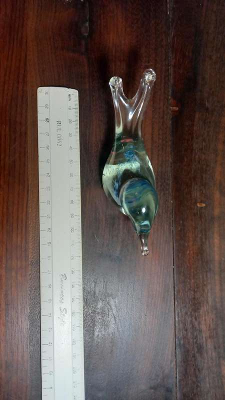 A SMALL DECORATIVE GLASS FIGURINE SHAPED LIKE A BIRD