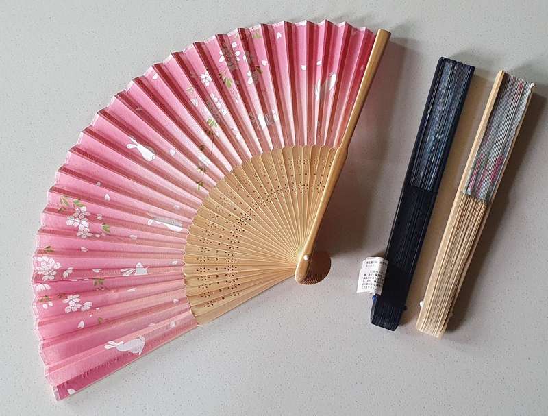 One pink colour hand-held folding fan as per photo