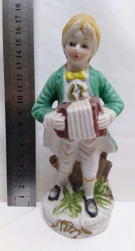 Beautiful vintage figurine boy with accordion