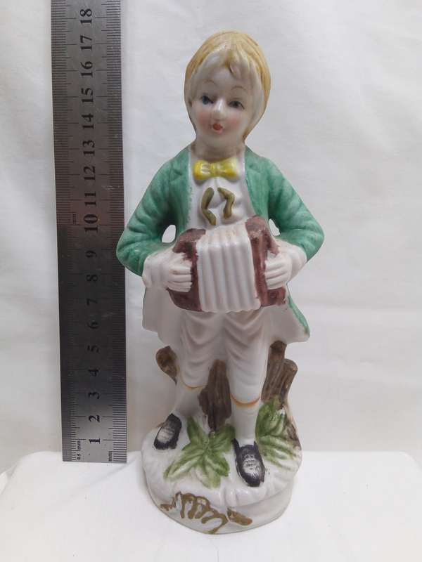 Beautiful vintage figurine boy with accordion