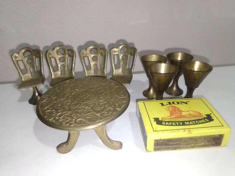 Handcrafted miniature bras dining table set that includes a table and four chairs and 4 goblets.