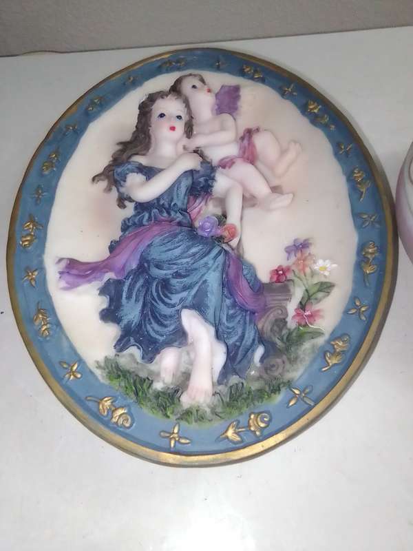 A Damsel and cherub Porcelain/polyresin wall plaque and a Cherub trinket lidded box.