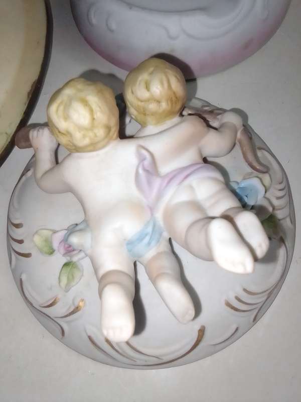 A Damsel and cherub Porcelain/polyresin wall plaque and a Cherub trinket lidded box.